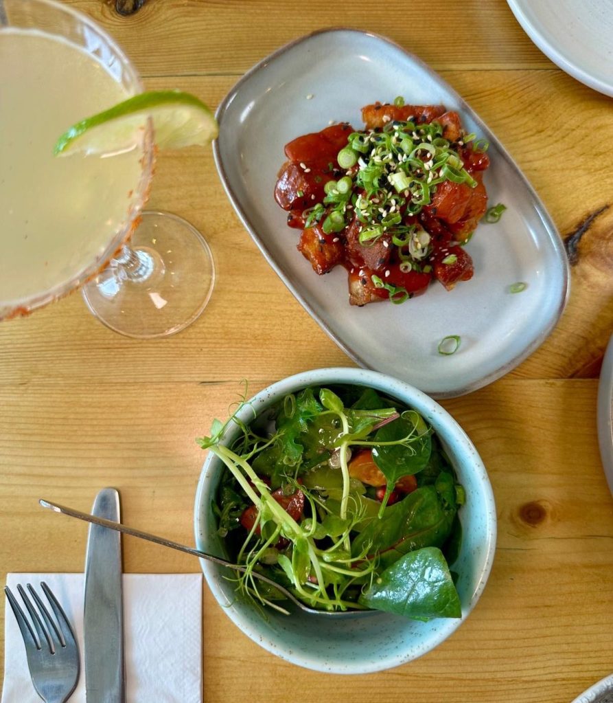 Sticky Korean pork belly served with sesame and spring onion, alongside a fresh seasonal salad at Isla in Durham.
