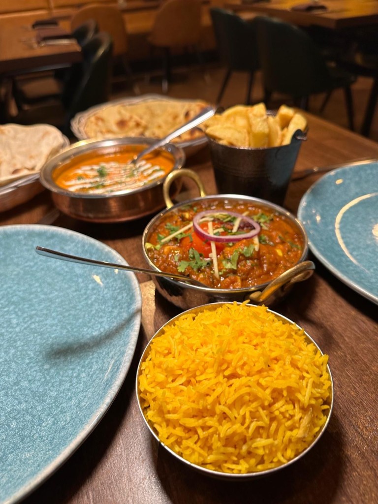 Selection of Indian dishes at Babaji Sunderland including starters, curries, bread, rice, and prawns.