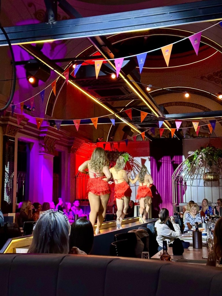 Purple Peacock Newcastle stage dancers performing on stage in vibrant costumes