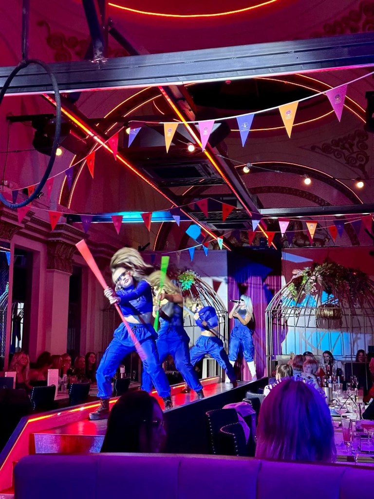 Purple Peacock Newcastle stage dancers performing on stage in vibrant costumes