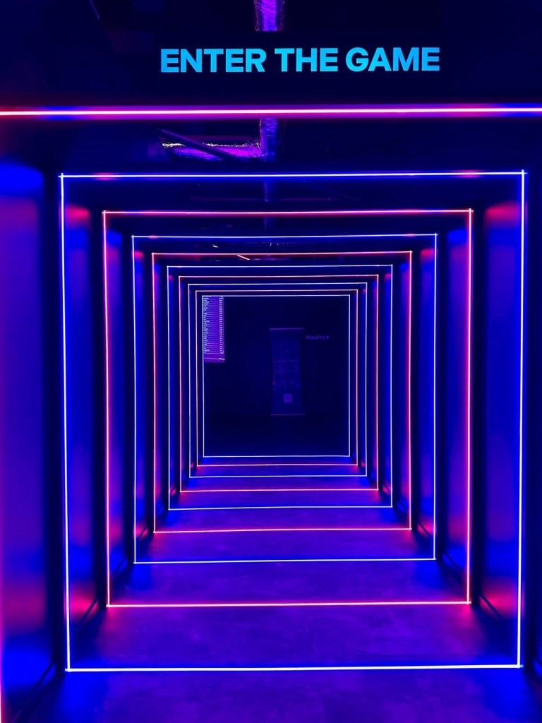 Activate Metrocentre entrance hallway in Gateshead illuminated with glowing neon lights leading to the gaming rooms
