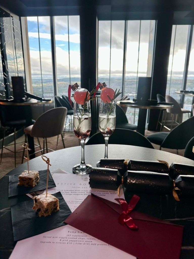Interior of 3Sixty Newcastle with festive cocktail and small squares of Christmas cake on the table.