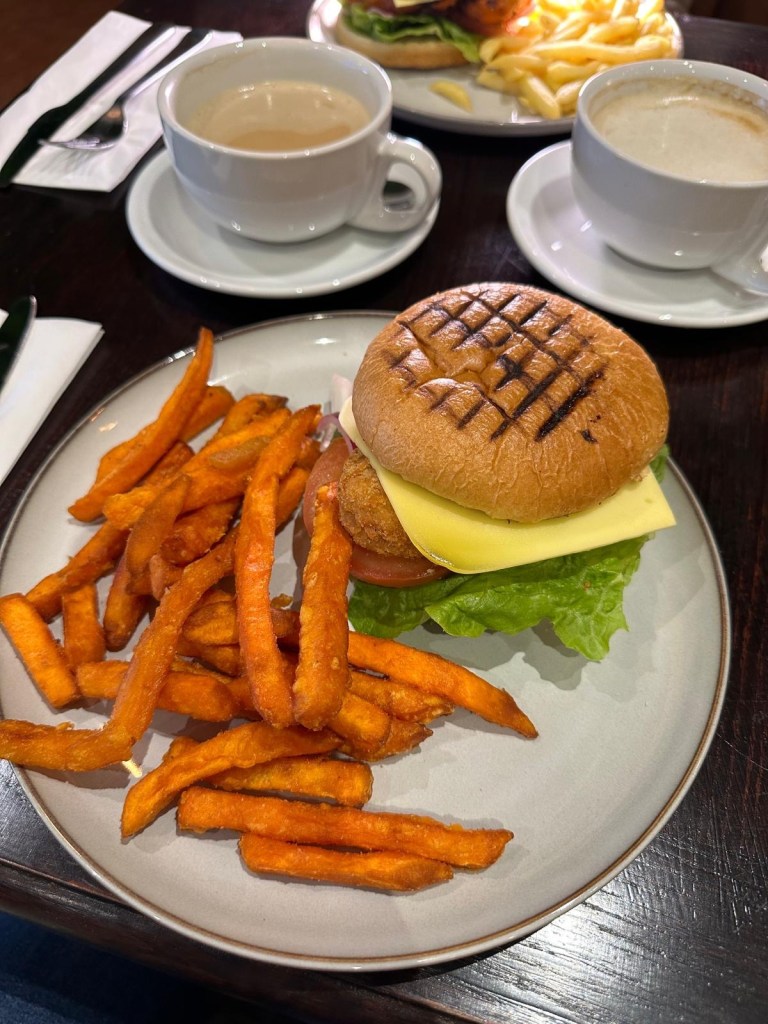 Vegan Bad Boy burger at Olive Kitchen Newcastle with quorn patty, vegan cheese, lettuce, tomato, onion, and vegan mayo in a toasted bun.