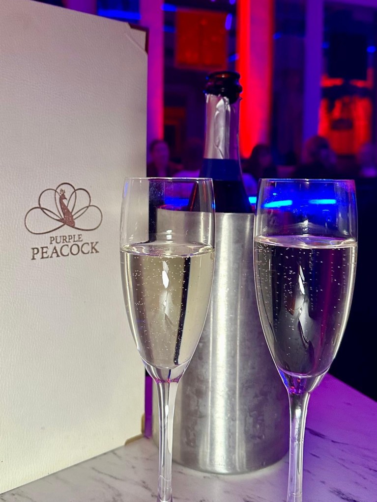 Purple Peacock Newcastle stage dancers performing on stage in vibrant costumes