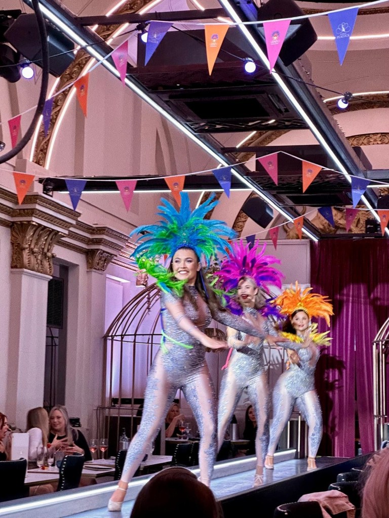 Purple Peacock Newcastle stage dancers performing on stage in vibrant costumes