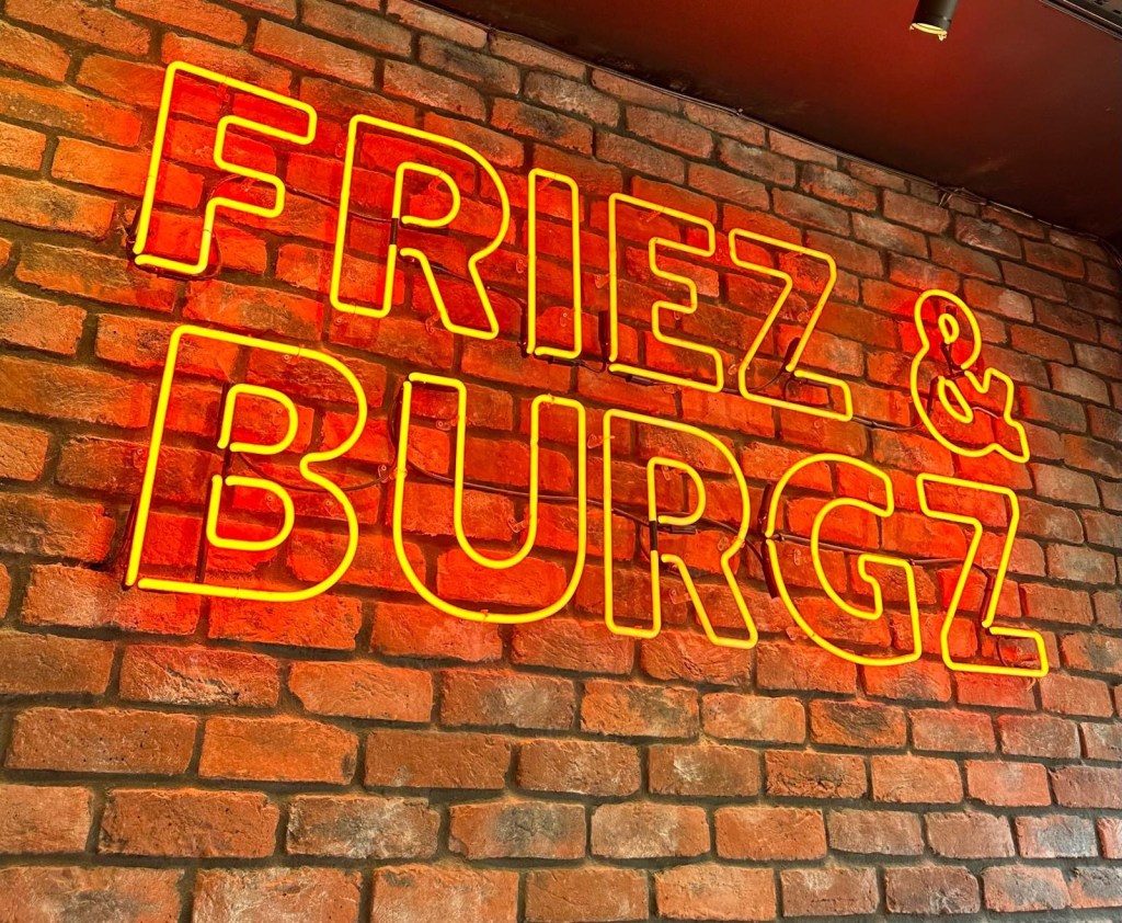 Neon sign at Friez&Burgz Newcastle adding vibrant decor.