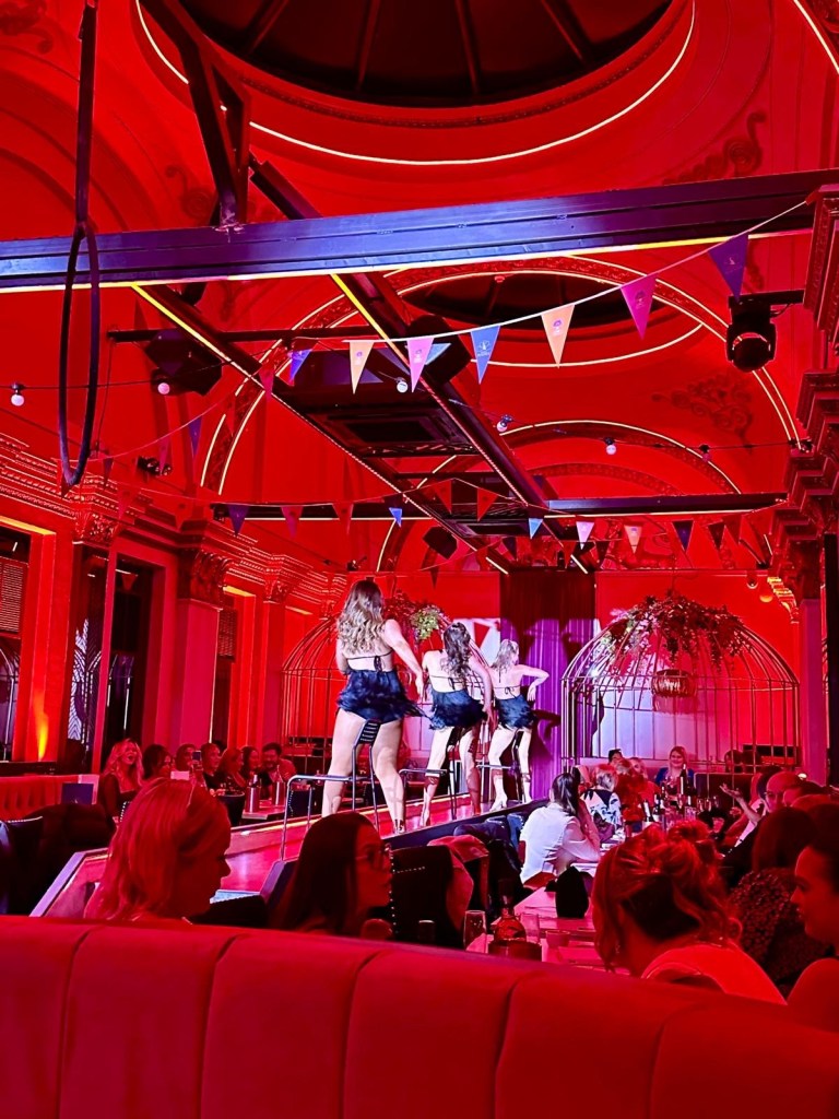 Purple Peacock Newcastle stage dancers performing on stage in vibrant costumes