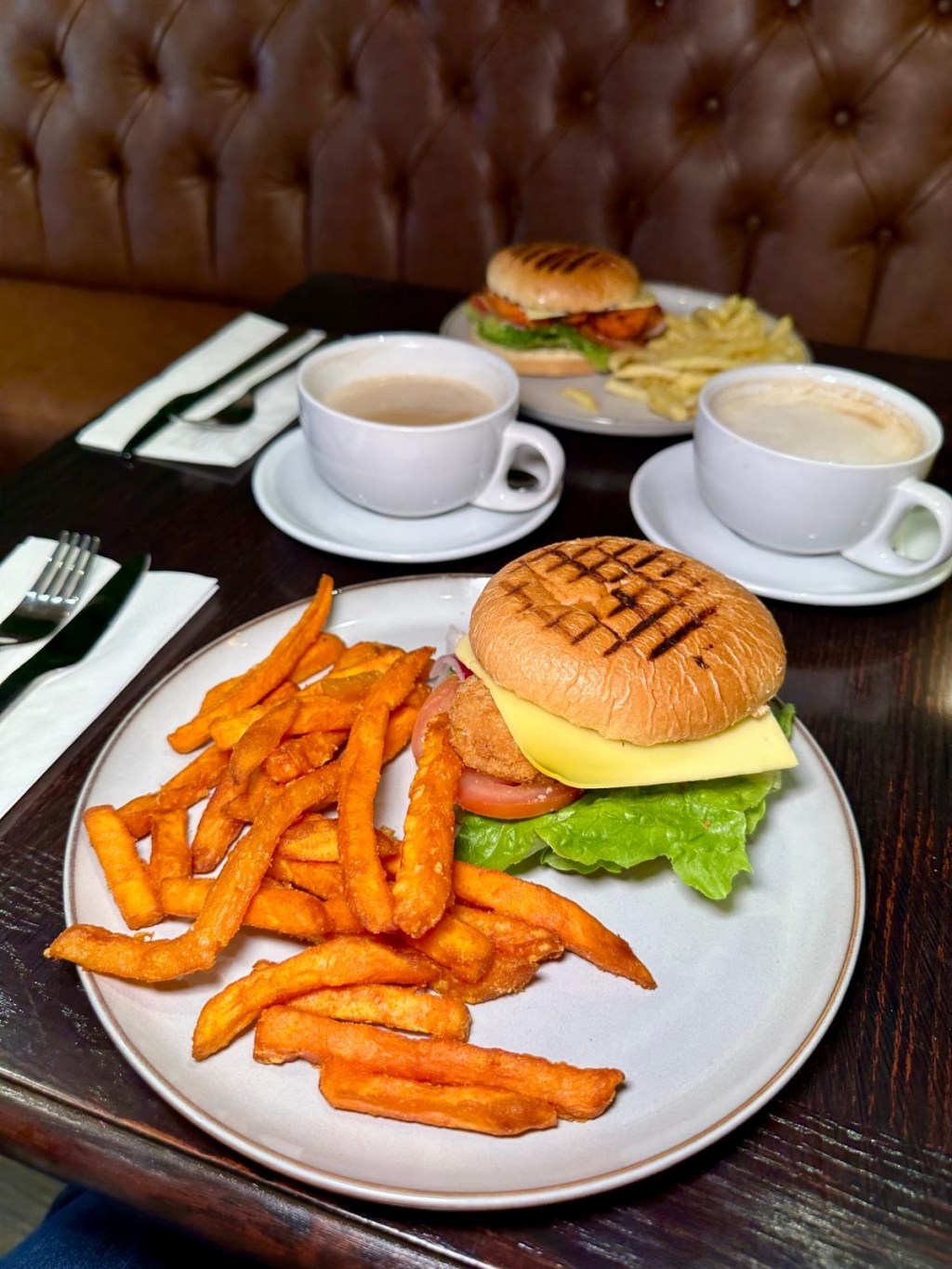 Vegan Bad Boy burger at Olive Kitchen Newcastle with quorn patty, vegan cheese, lettuce, tomato, onion, and vegan mayo in a toasted bun.