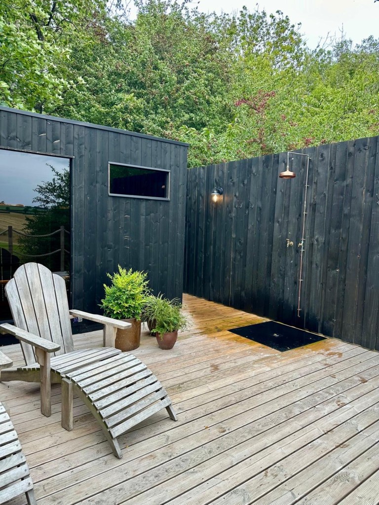 Finnish-style sauna with sundeck, loungers, and cold shower at Hewn Yorkshire.