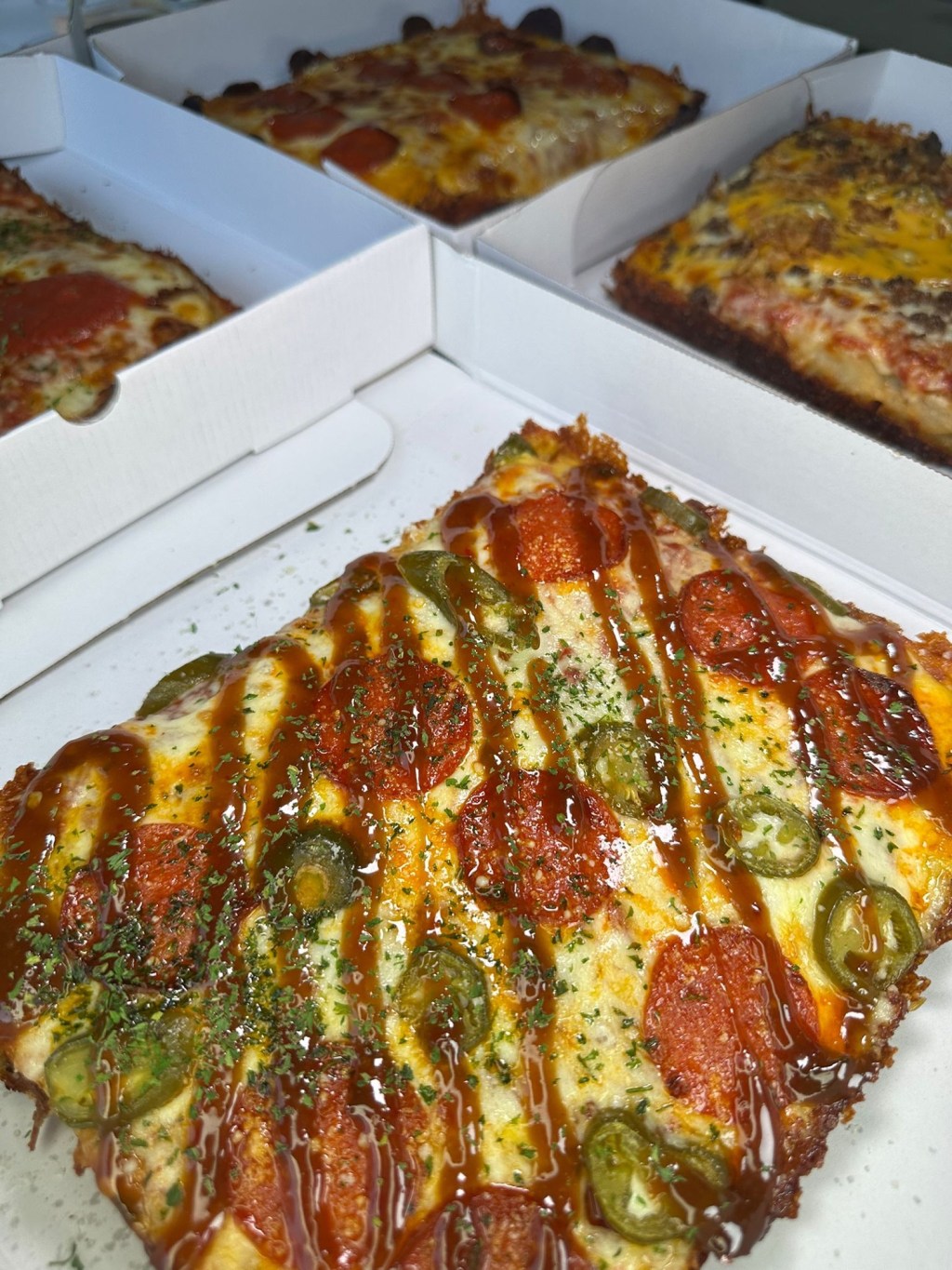 Detroit-style Signature Slab pizza topped with pepperoni, jalapeños, chilli caramel and parmesan cheese, served in Newcastle.