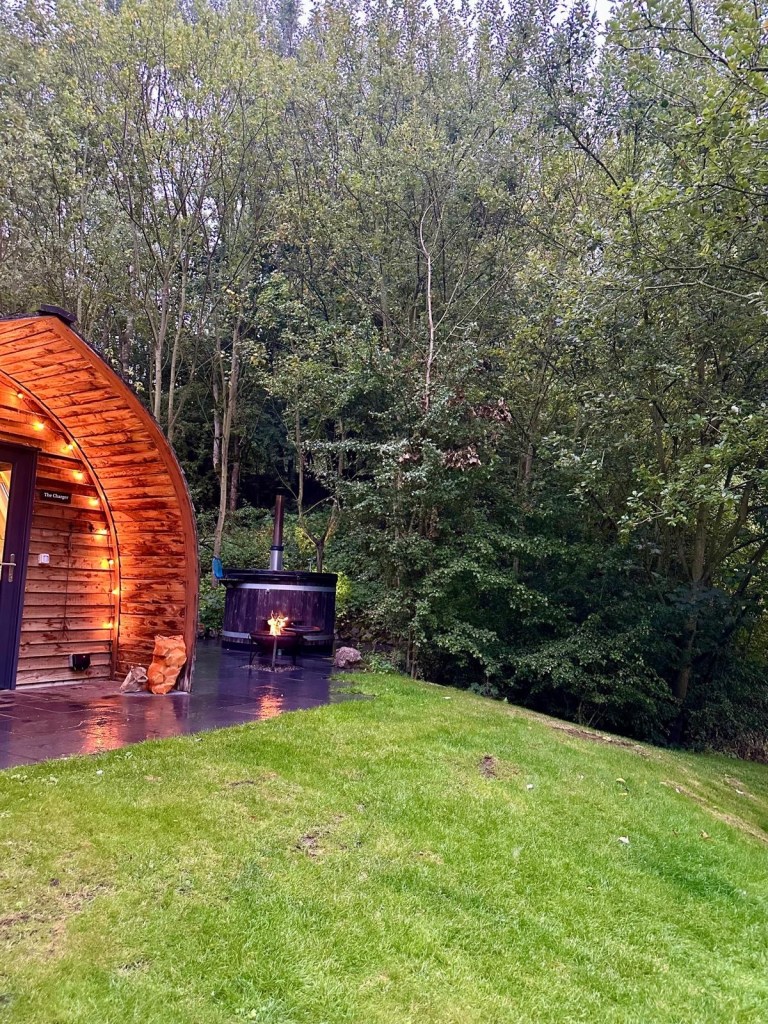 Outdoor hot tub, fire pit, and sauna at Hewn Yorkshire.