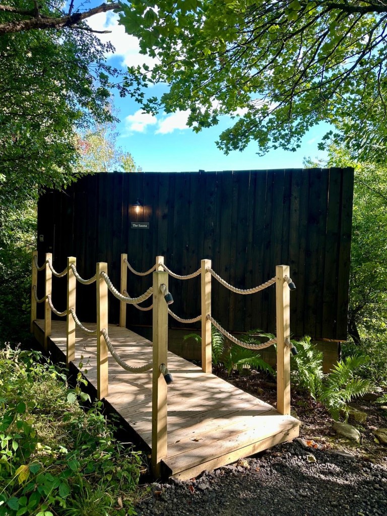 Finnish-style sauna with sundeck, loungers, and cold shower at Hewn Yorkshire.
