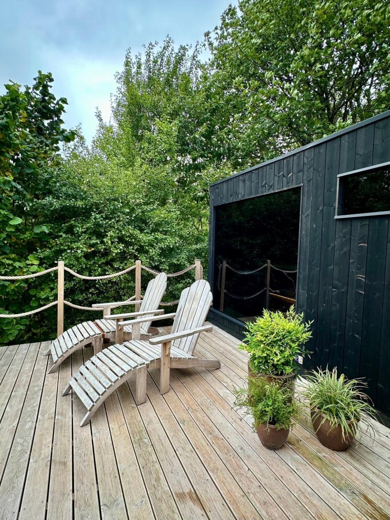 Finnish-style sauna with sundeck, loungers, and cold shower at Hewn Yorkshire.