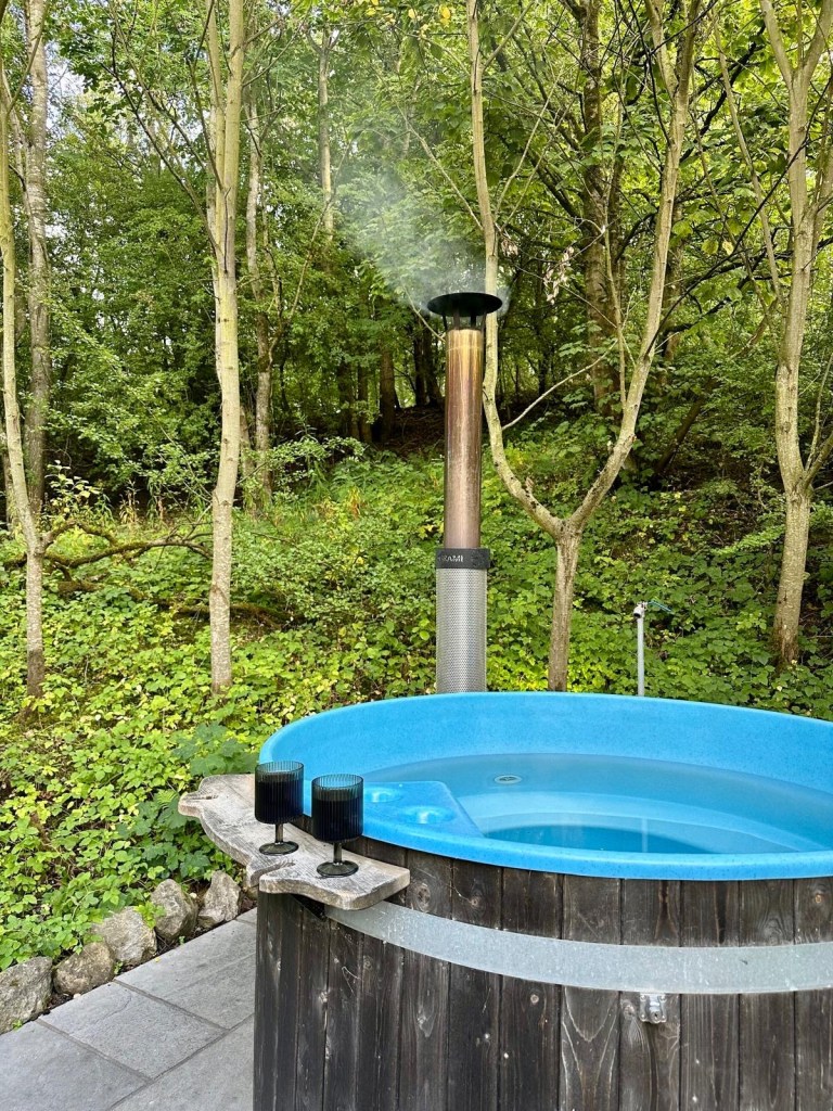 Outdoor hot tub, fire pit, and sauna at Hewn Yorkshire.
