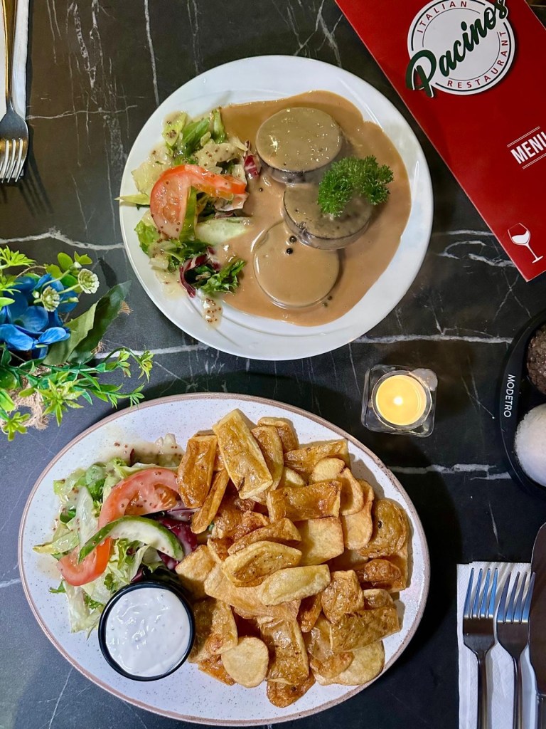 Starters at Pacino’s South Shields featuring crispy potato skins with garlic mayo and black pudding al pepe in creamy peppercorn sauce.