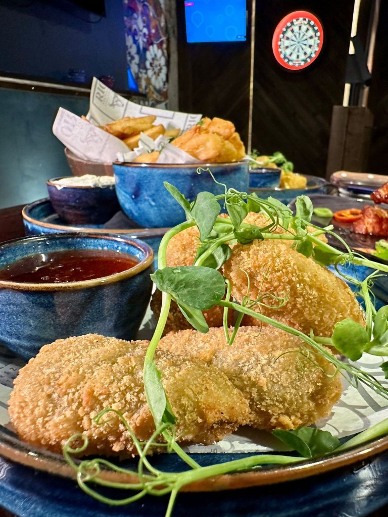 Selection of small plates at Bullseye Social Darts in Jesmond including chilli and cheese bites, mac and cheese bites, jalapeño poppers, hot honey halloumi, sautéed king prawns with focaccia, crispy yuca fries and truffle fries.