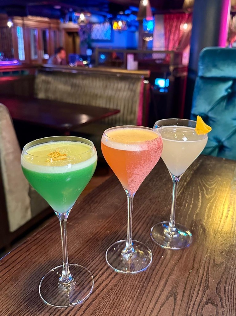 Three colourful cocktails at Manahatta Newcastle displayed on the table, featuring fruity, floral and tequila-based drinks from the new menu.