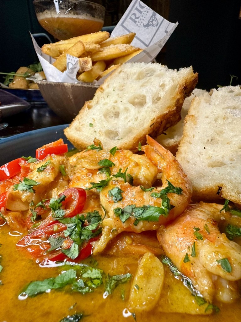 Sautéed king prawns in garlic butter and piri piri sauce served with warm focaccia bread at Bullseye Social Darts Jesmond.