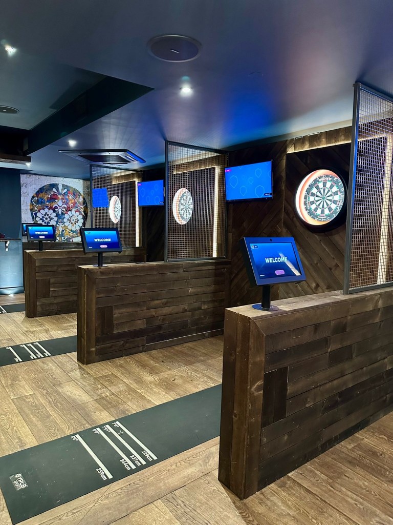 Modern social darts venue in Jesmond with cosy lighting, neon signs, digital dartboards and a stylish boujee interior at Bullseye Social Darts.