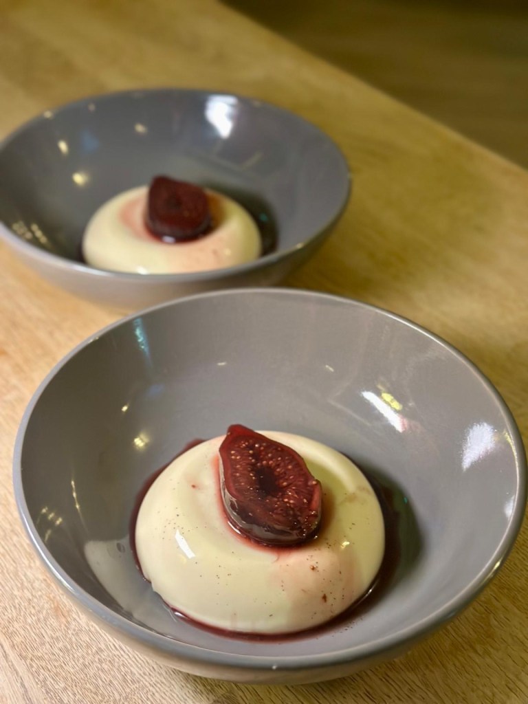 Honey panna cotta topped with roasted figs and a whiskey drizzle.