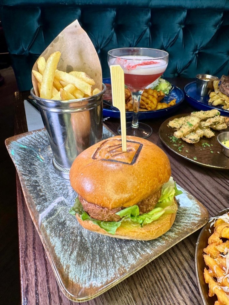 Deluxe Burger at Manahatta Newcastle with classic toppings, available as beef, veggie or vegan.