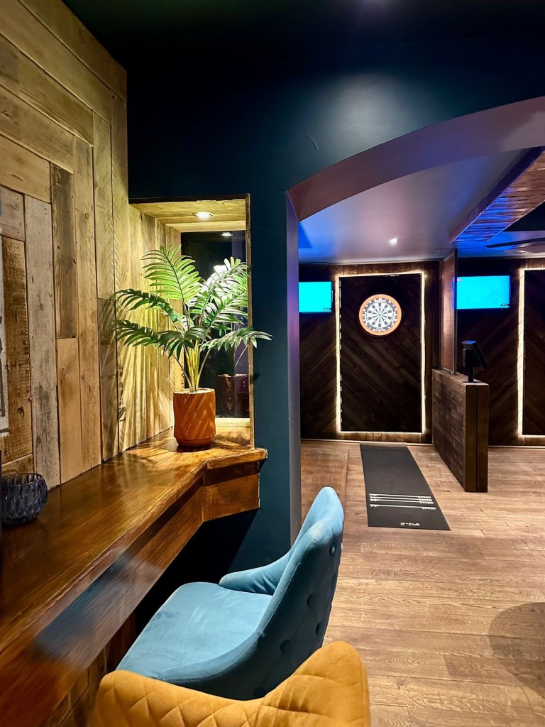 Modern social darts venue in Jesmond with cosy lighting, neon signs, digital dartboards and a stylish boujee interior at Bullseye Social Darts.