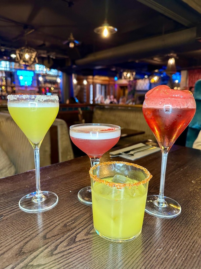 Four colourful cocktails at Manahatta Newcastle displayed on the table, featuring fruity, floral and tequila-based drinks from the new menu.