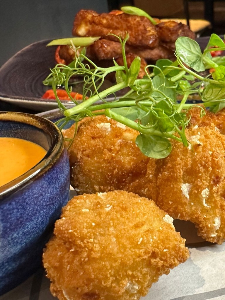 Selection of small plates at Bullseye Social Darts in Jesmond including chilli and cheese bites, mac and cheese bites, jalapeño poppers, hot honey halloumi, sautéed king prawns with focaccia, crispy yuca fries and truffle fries.