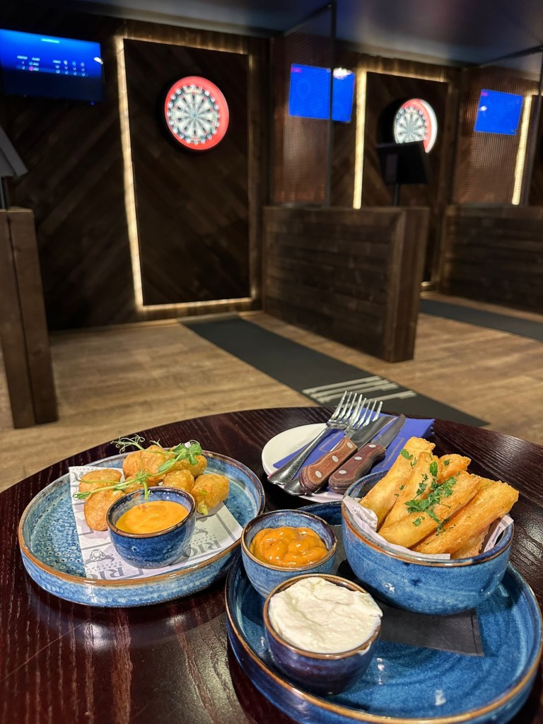 Selection of small plates at Bullseye Social Darts in Jesmond including chilli and cheese bites, mac and cheese bites, jalapeño poppers, hot honey halloumi, sautéed king prawns with focaccia, crispy yuca fries and truffle fries.