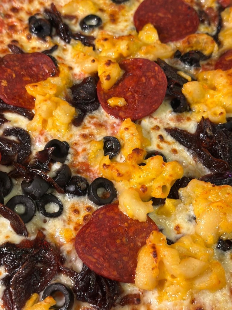 Sourdough pizza with a delicious selection of toppings with golden mozzarella melted cheese