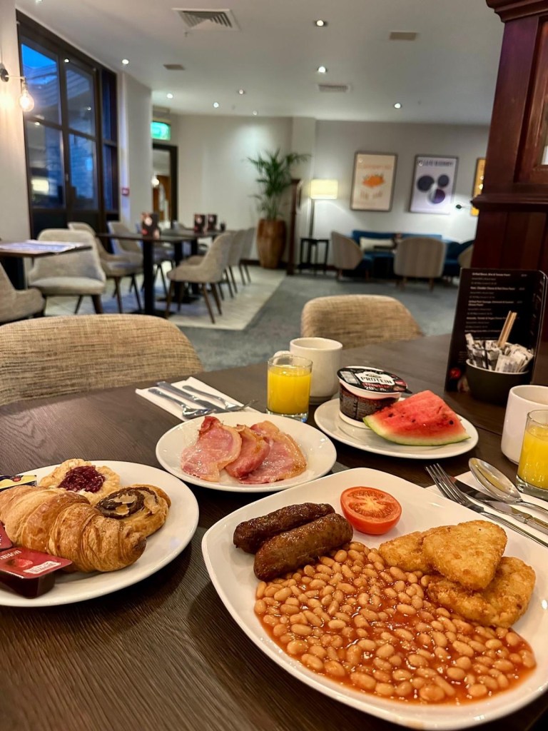 Full English breakfast served on a table at Delta Hotels by Marriott Newcastle Gateshead, including eggs, bacon, sausages, tomatoes and toast.