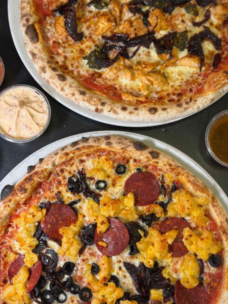 Sourdough pizza with a delicious selection of toppings with golden mozzarella melted cheese