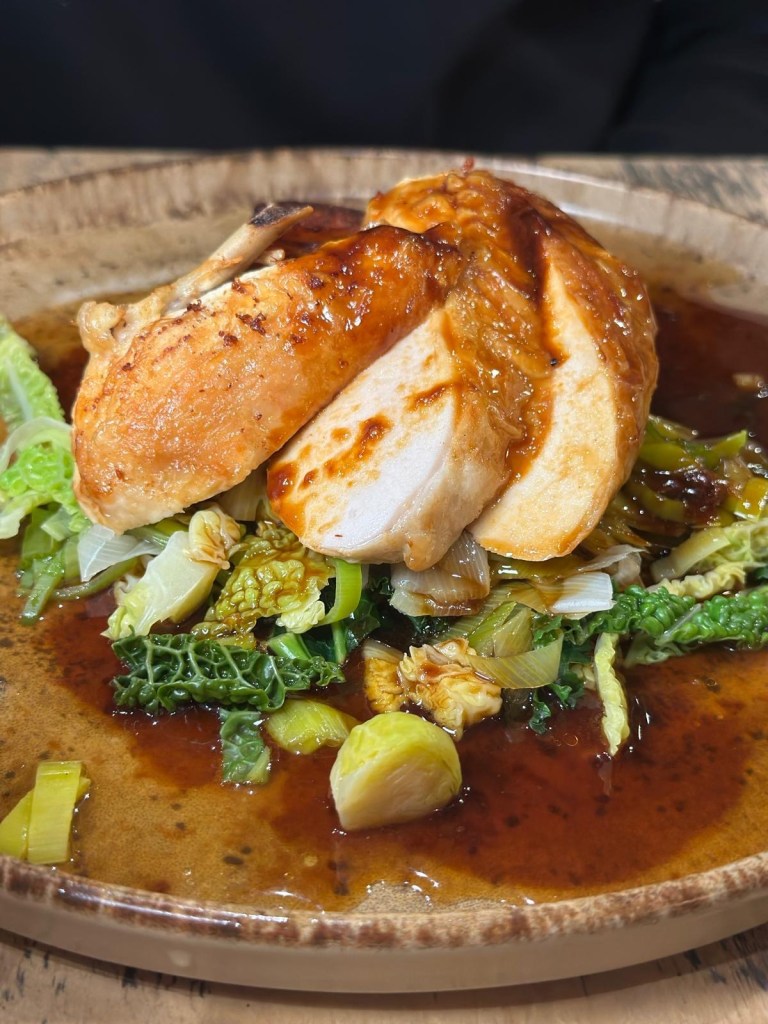 Pan roasted chicken breast with potato gratin, sprout tops, leeks and truffled jus at Hinnies restaurant
