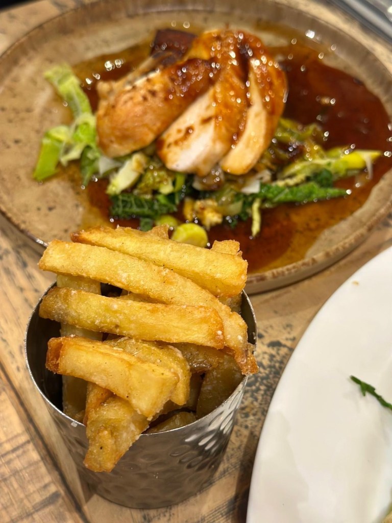 Pan roasted chicken breast with potato gratin and parmesan truffle fries at Hinnies Whitley Bay