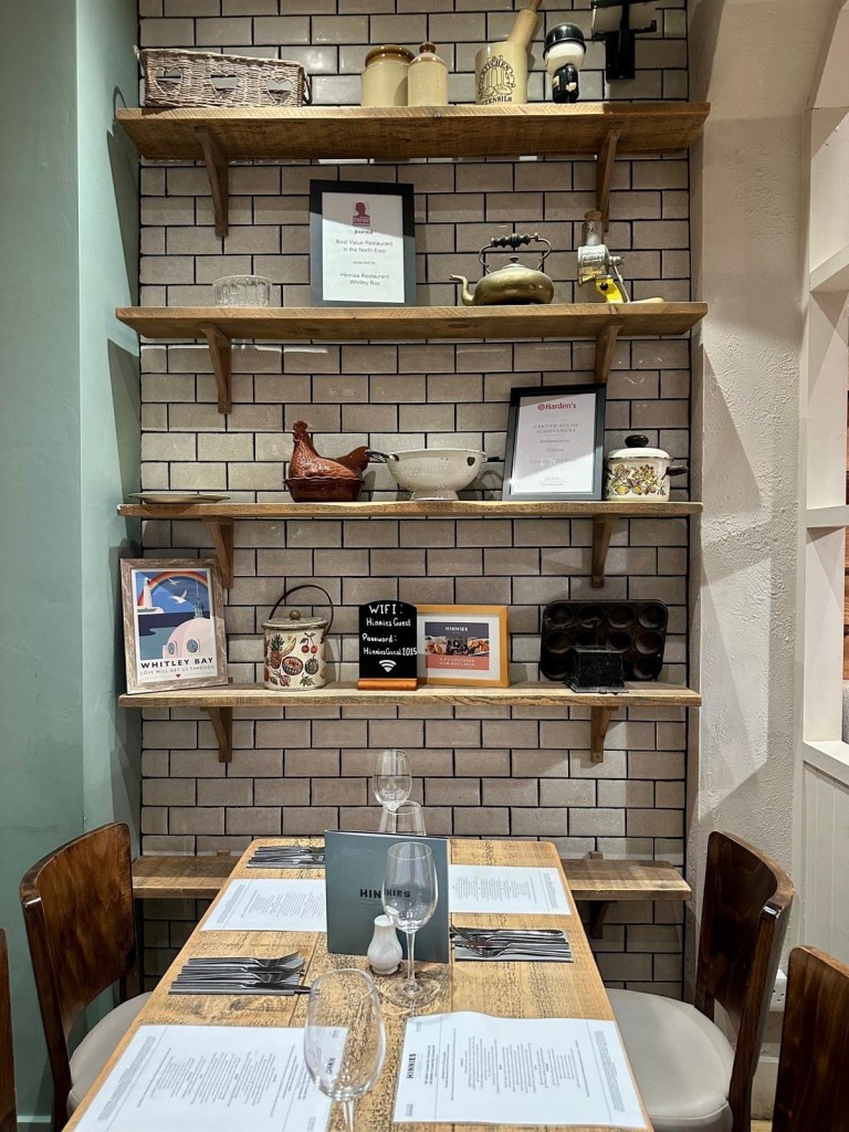 Interior dining table set with wall decor inside Hinnies restaurant in Whitley Bay