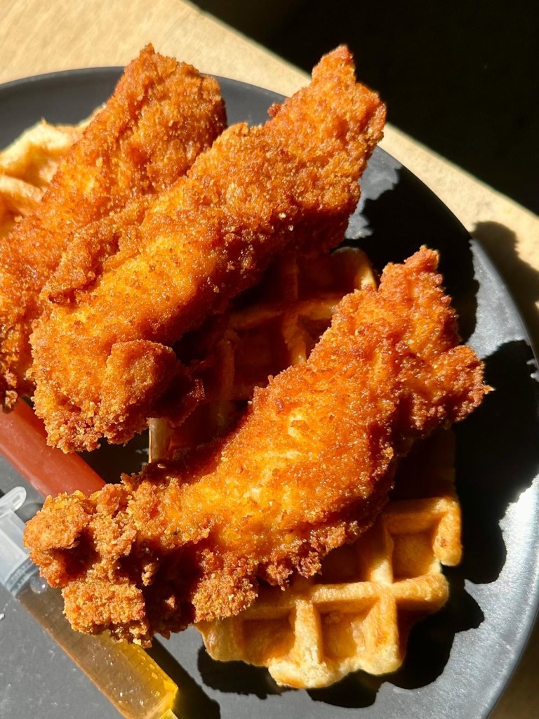 Cornflake crusted fried chicken and waffles with maple syrup and honey buffalo sauce served at The Dispensary brunch café in Newcastle.