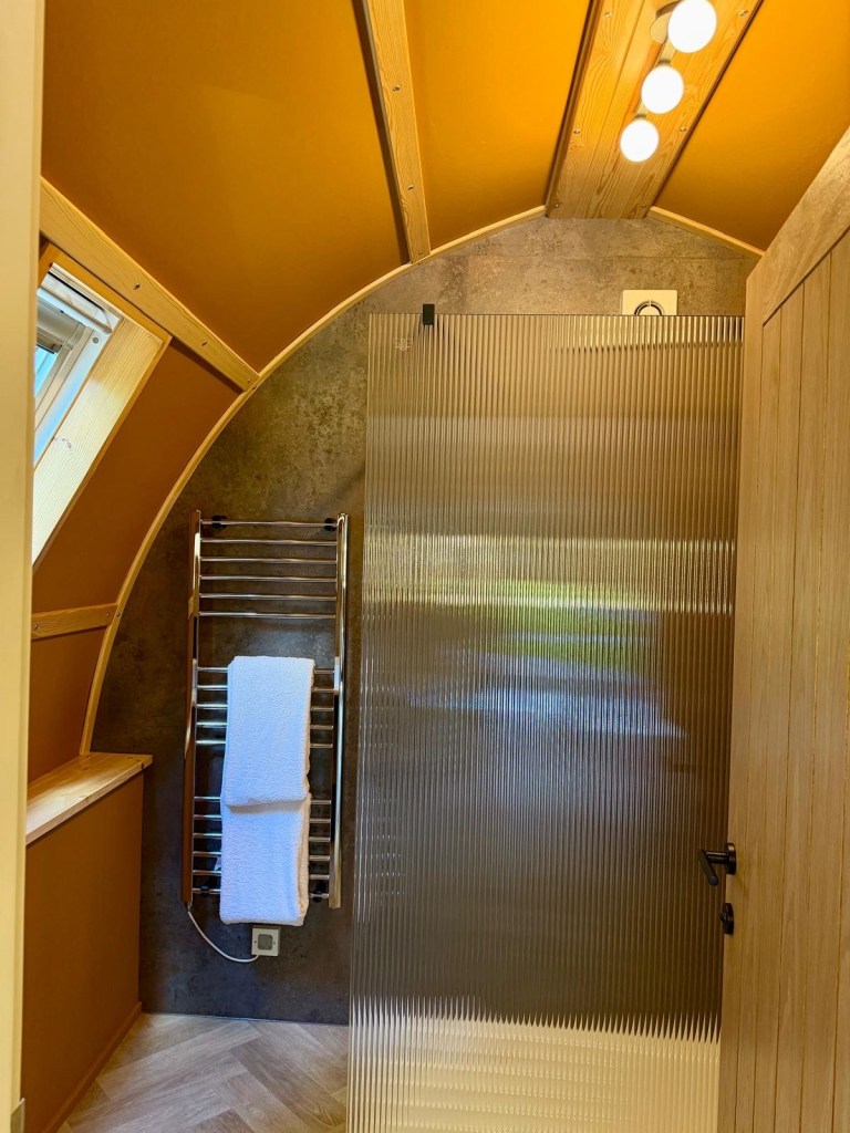 Luxury cabin bathroom with rainfall shower at Hewn Yorkshire