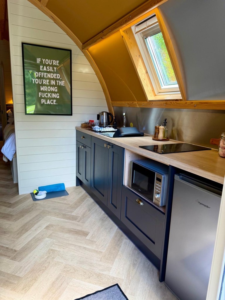 Modern kitchenette inside a Hewn Yorkshire cabin with stylish cupboards and amenities