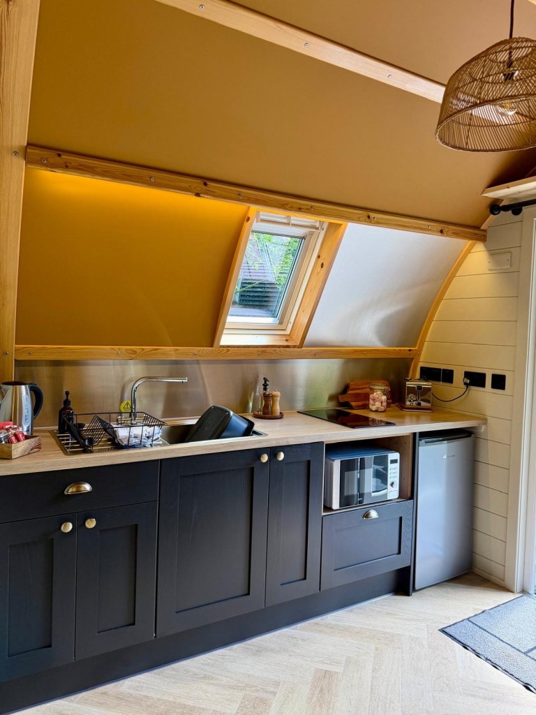 Modern kitchenette inside a Hewn Yorkshire cabin with stylish cupboards and amenities